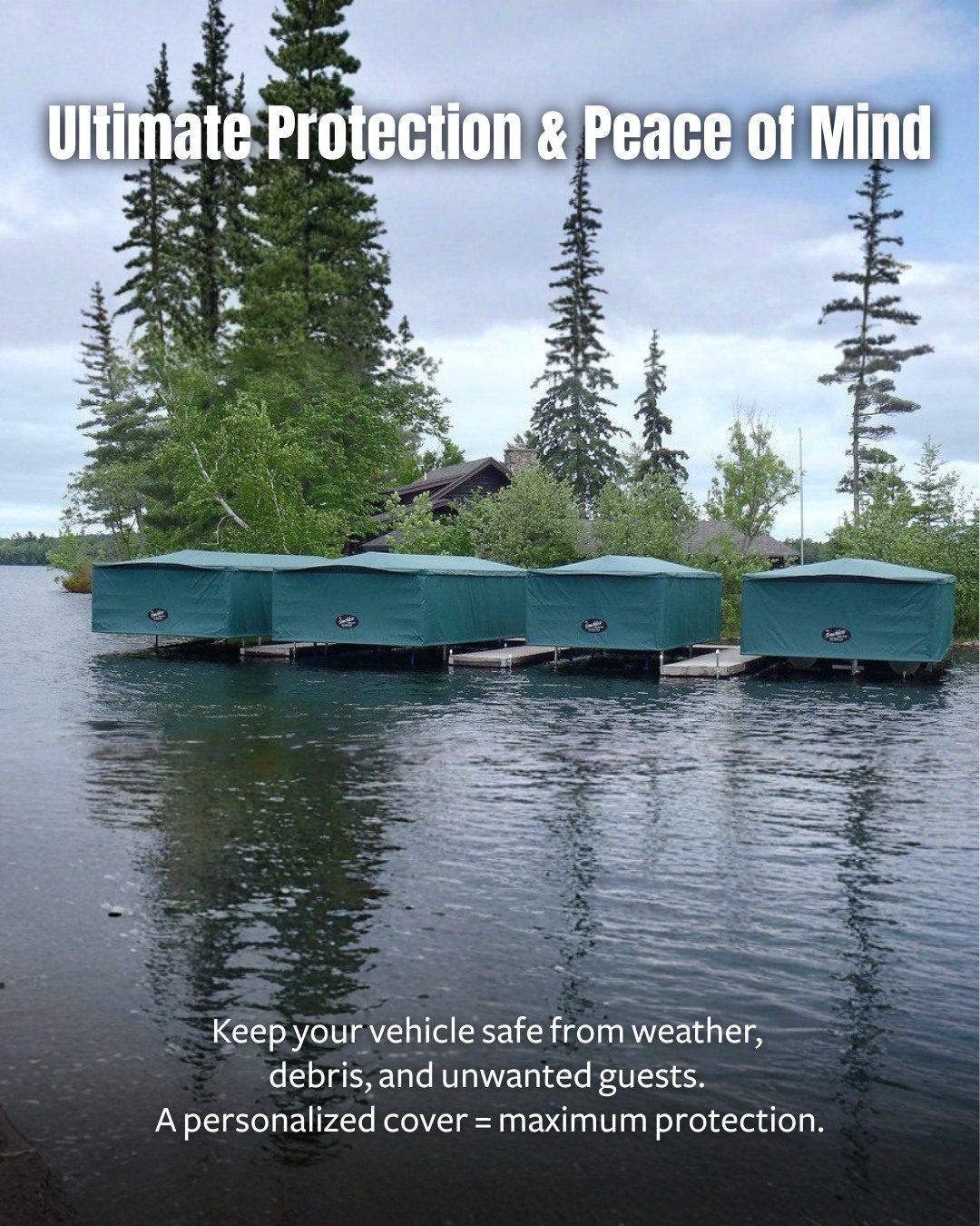 Multiple boats docked beneath green Touchless Cover® canopies on a calm lake, surrounded by evergreens and a cabin.