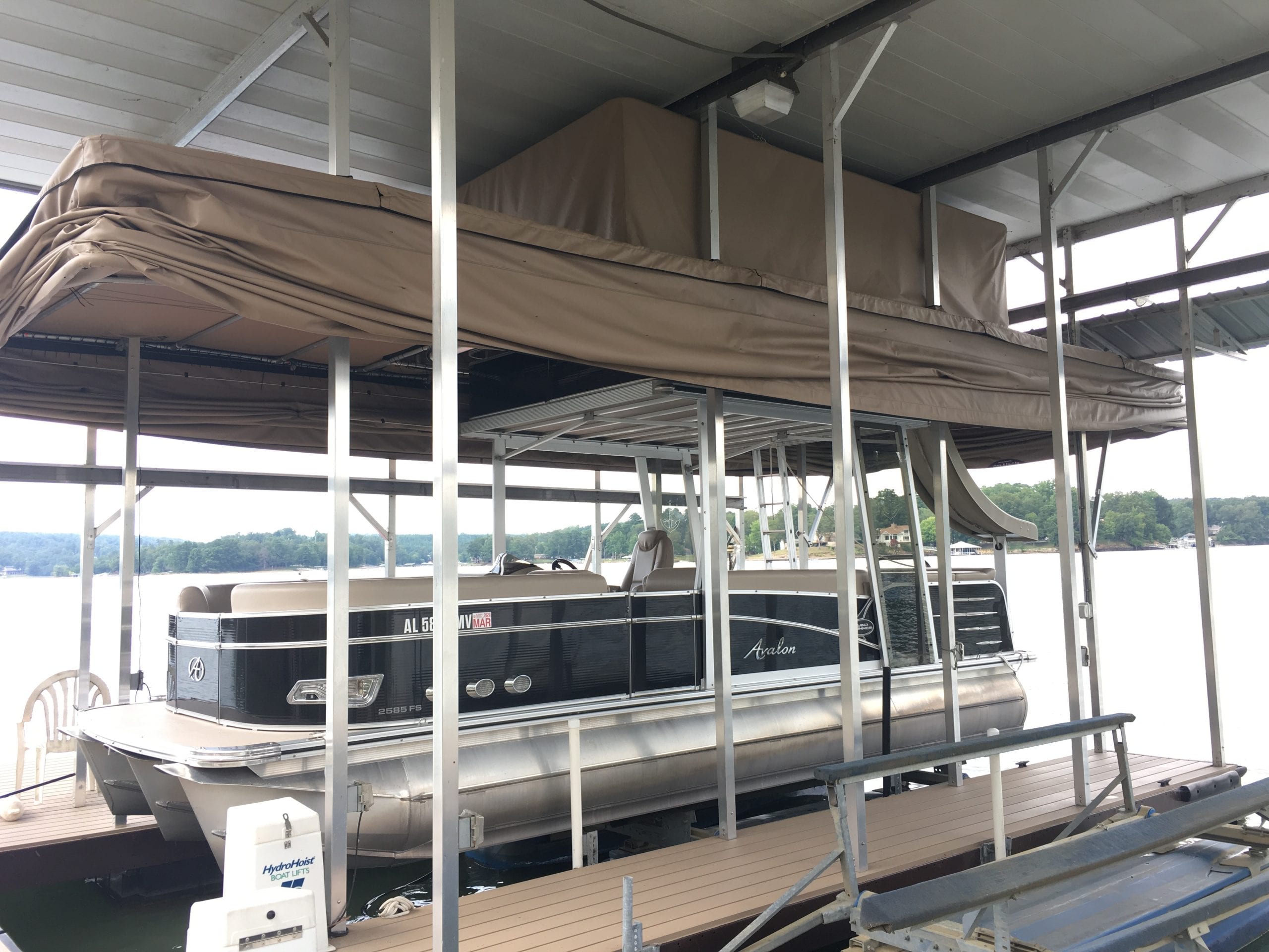 Pontoon boat interior with seating and helm area protected from sun and weather exposure