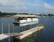 Boat moored at dock with Touchless Cover® under cloudy blue sky