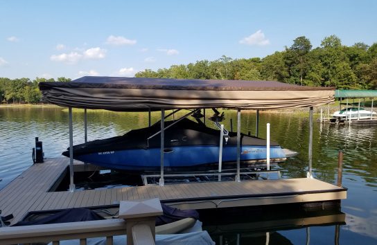 Ski boat with automatic cover docked under canopy