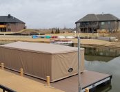 Pontoon boat docked under a Touchless Automatic Boat Cover for full weather protection