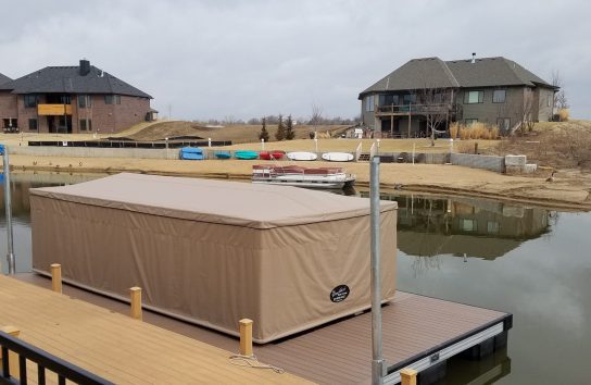 Pontoon boat docked under a Touchless Automatic Boat Cover for full weather protection