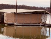 Boat house with pontoon boat and Touchless Boat Cover on lake
