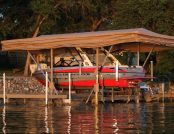 Ski boat parked beneath an automatic boat cover on a dock.