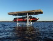 Ski boat docked with automatic cover and gentle waves