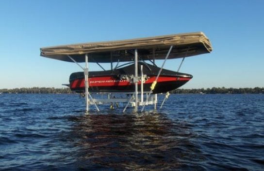 Ski boat docked with automatic cover and gentle waves