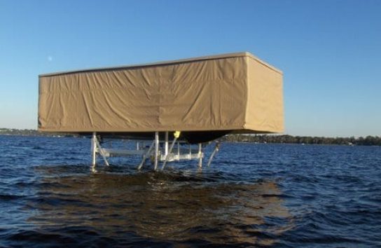 Automatic boat cover on ski boat docked in lake center