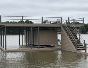 Dock with stairs beside pontoon boat protected by Touchless Boat Cover