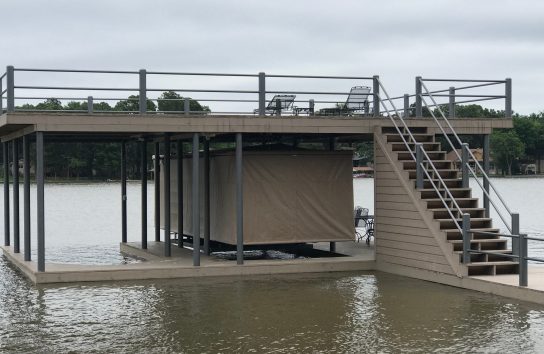 Dock with stairs beside pontoon boat protected by Touchless Boat Cover