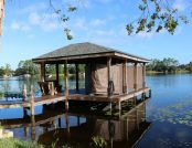 Boat dock with a boat equipped with an automatic ski boat cover, ready for use.
