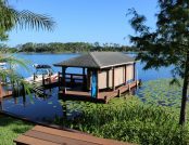 Boat dock showcasing a boat under an automatic ski boat cover, positioned on the dock.
