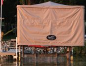 Touchless Automatic Boat Cover providing full shade for a ski boat on the dock.
