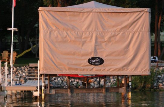 Touchless Automatic Boat Cover providing full shade for a ski boat on the dock.