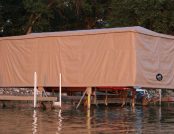 Dock with Touchless Automatic Boat Cover offering protection for a ski boat.