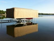 Docked ski boat in the middle of a lake, fully protected by a Touchless Boat Cover on a peaceful afternoon.