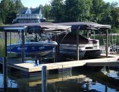 Ski boat and wake boat docked on Lake Wylie with Touchless Automatic Boat Covers ready for remote deployment.