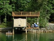 Pontoon boat covered by light brown automatic Touchless Cover® in Southern California boathouse